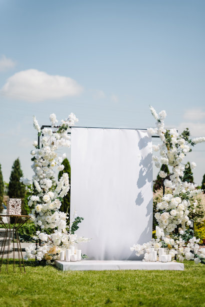 拱门上装饰的是鲜花、青菜、绿色植物、蜡烛。举办豪华婚礼的地点。后院时髦的装饰。照片墙，文字空间。庆祝洗礼的概念。生日宴会招待会。图片下载