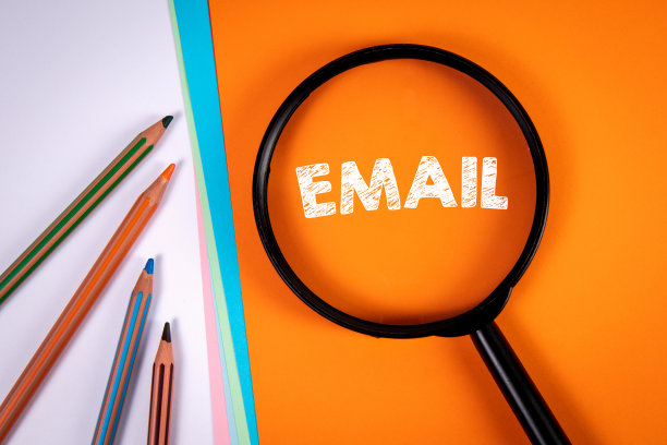 邮件：橙色背景上的放大镜和白色铅笔图片下载