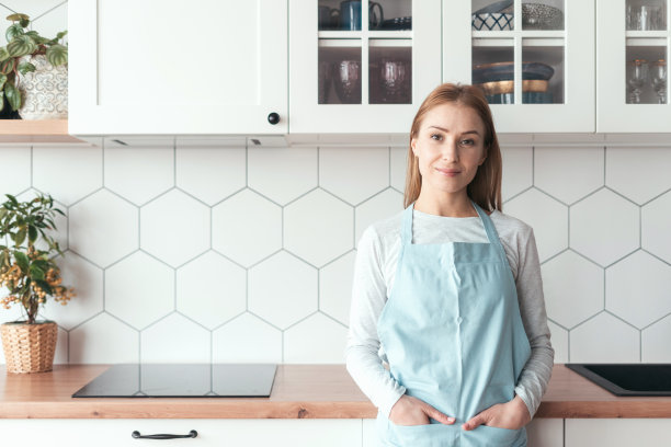 身穿围裙的年轻女子微笑着看着镜头图片下载