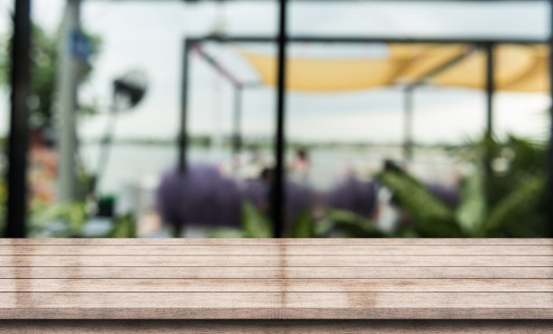 空的木制桌面与灯光散景在模糊的餐厅背景。图片下载