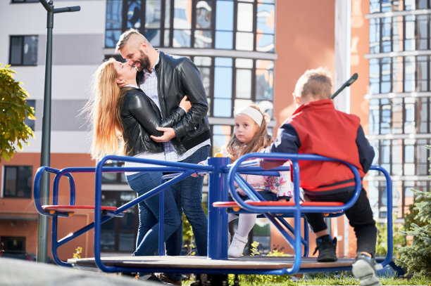 在温暖的秋日，一家人在操场上玩耍。图片下载