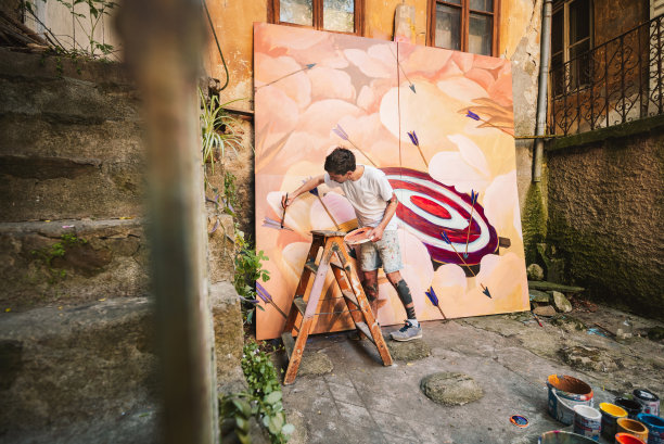 男艺术家正在画一幅巨画。图片下载