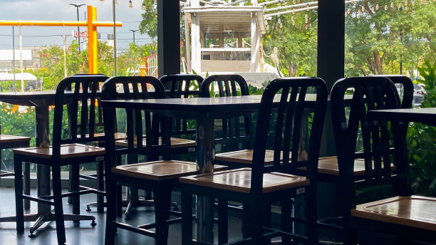 泰国一家餐厅的桌椅，内部色调为深色。图片下载