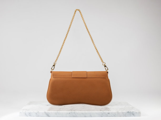 奢侈女包。白色背景的豪华橙色皮革手袋，大理石地板图片下载