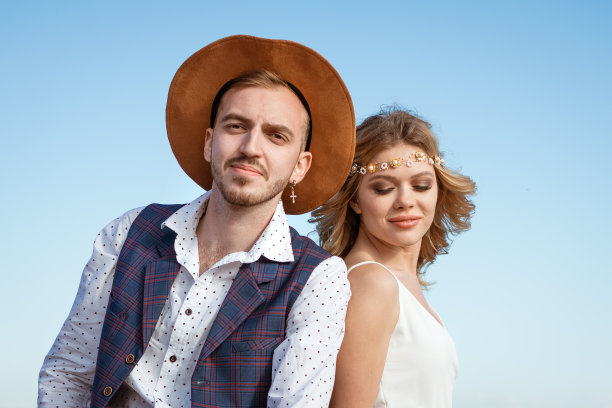 一对幸福的情侣拿着一束花在海滩上图片下载