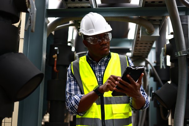 服务工程师正在检查污水处理厂，后台是管道。在污水处理厂工作的工人图片下载