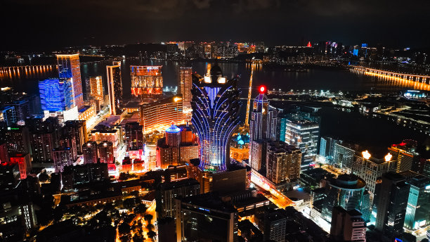 新葡京赌场摩天大楼的城市景观，汽车交通运输的桥梁道路在澳门岛。无人机航拍夜景。亚洲旅游地标概念图片下载