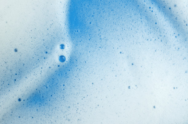 蓝色背景上白色洗发水或洗涤剂泡沫的微距照片图片下载