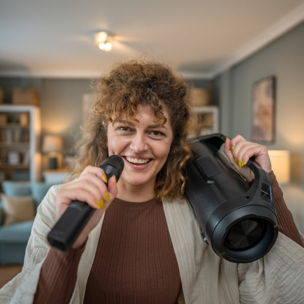 一名女子青年在家里拿着麦克风开心地笑着唱歌跳舞图片下载