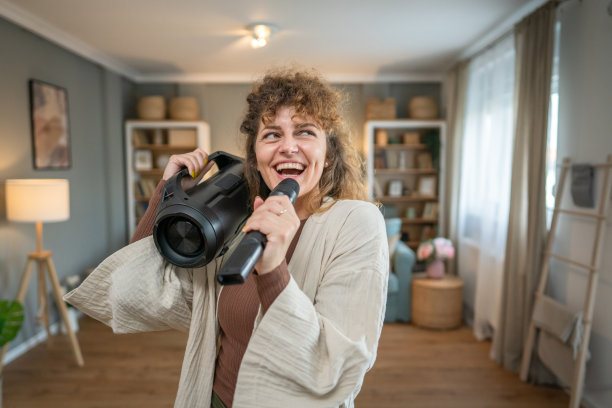 一名女子青年在家里拿着麦克风开心地笑着唱歌跳舞图片下载