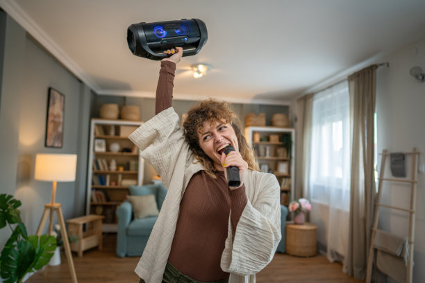 一名女子青年在家里拿着麦克风开心地笑着唱歌跳舞图片下载