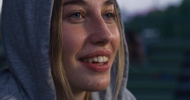 美丽的白人女性在户外运动中休息的特写肖像。出汗和疲劳的女运动员感到快乐和动力，感谢她的进步和耐力图片下载