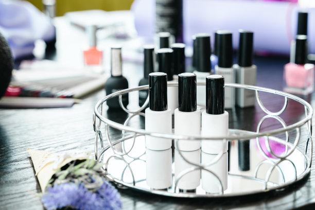 许多装着各种颜色指甲油样品的调色板和瓶子。粉色，紫色，法式美甲。美容院的专业美甲师。美甲服务，手部护理，手指护理图片下载