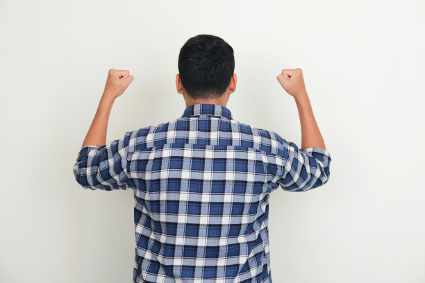 一个男人紧握双手的背影，展示着成功的姿态图片下载