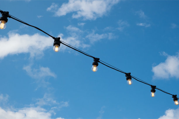 白色的节能灯泡上一根电线，湛蓝的天空，为傍晚的城市增添了美丽的装饰。图片下载
