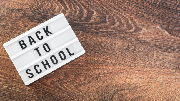 回到学校的概念。木制背景的学习用品。回到学校的白色白板上的字母。文本的复制空间。包括选择性焦点图片下载