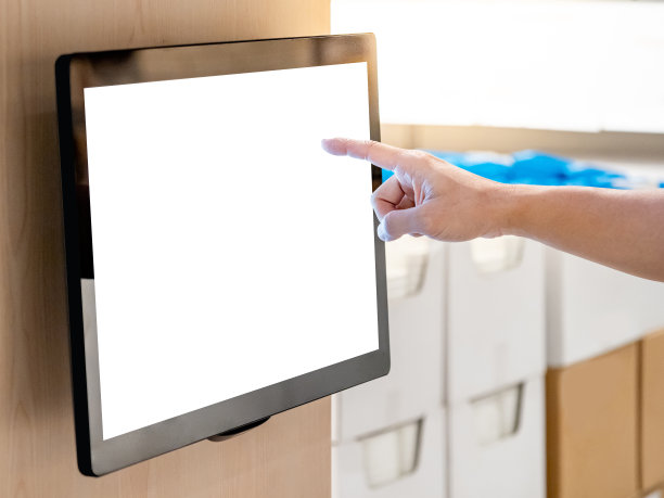 在商场使用交互式触摸屏显示。男顾客用手触摸墙上的液晶触摸屏显示器，浏览百货公司的信息。图片下载