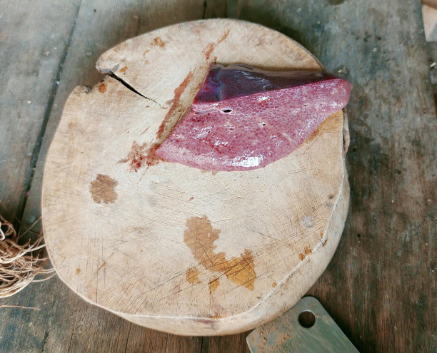 一张木制砧板上有一块肉的照片，有一块肉在木板上。图片下载