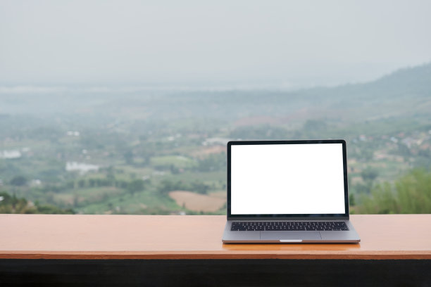 我坐在山顶上，一边用笔记本电脑工作，一边欣赏着美丽的云和山。图片下载