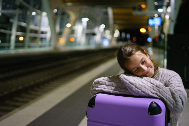 迷人的小女孩游客晚上在车站等火车图片下载