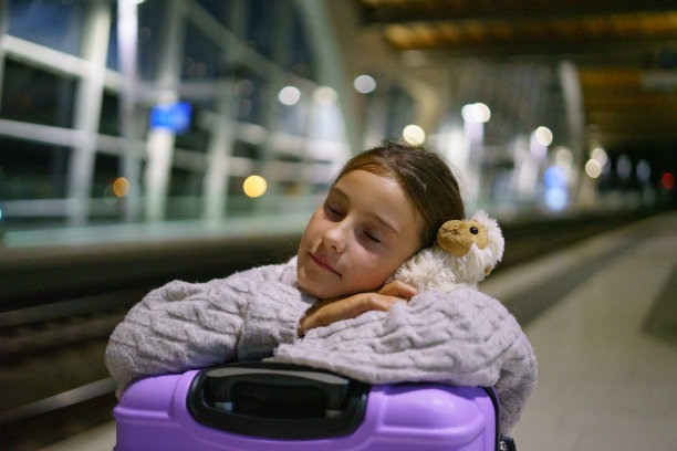 迷人的小女孩游客晚上在车站等火车图片下载