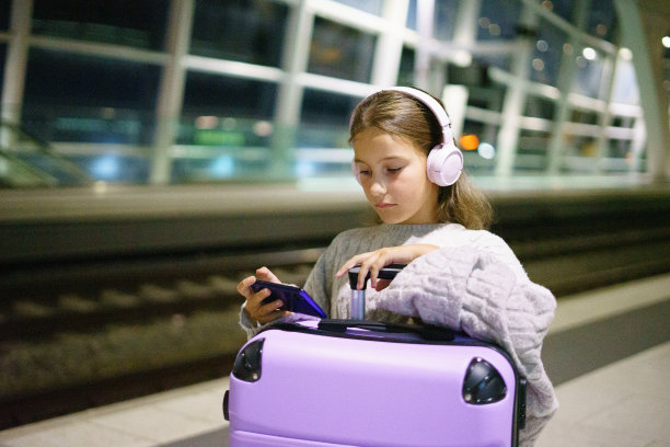 迷人的小女孩游客晚上在车站等火车图片下载