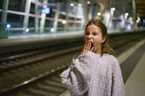 迷人的小女孩游客晚上在车站等火车图片下载