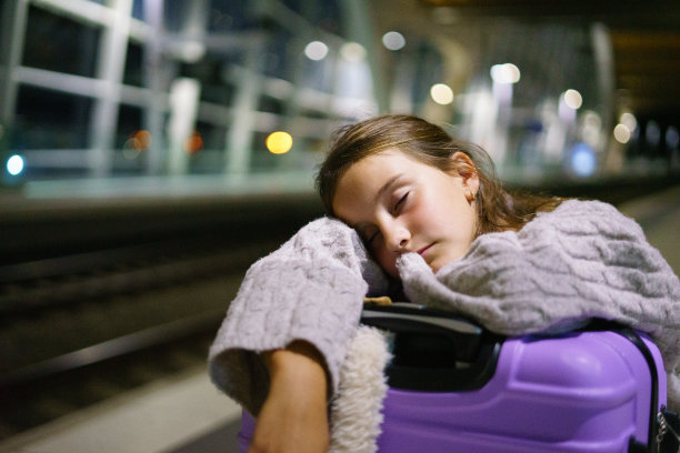 迷人的小女孩游客晚上在车站等火车图片下载