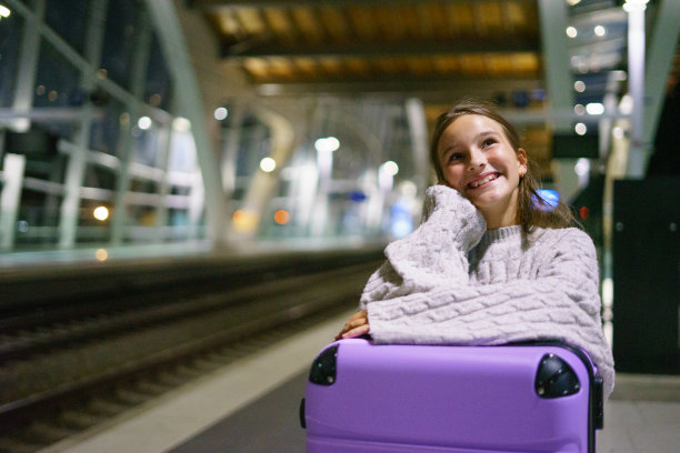 迷人的小女孩游客晚上在车站等火车图片下载