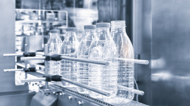 瓶子。工业生产塑料宠物瓶。工厂生产线生产聚乙烯瓶。透明食品包装。图片下载