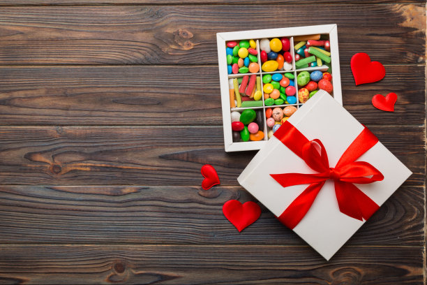 情人节作文:甜甜的糖果，带蝴蝶结和红心毡礼盒，照片模板，背景。带复制空间的俯视图图片下载