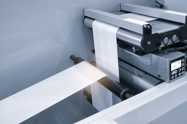 适用于产品、食品塑料包装的光效全自动工业机械。轴上的自动包装线用塑料薄膜呈现浅蓝色景象。产品包装理念图片下载