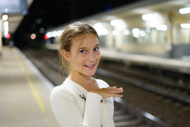 小时尚可爱的女孩在晚站等火车图片下载