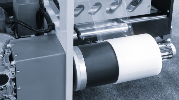 适用于产品、食品塑料包装的光效全自动工业机械。轴上的自动包装线用塑料薄膜呈现浅蓝色景象。产品包装理念图片下载