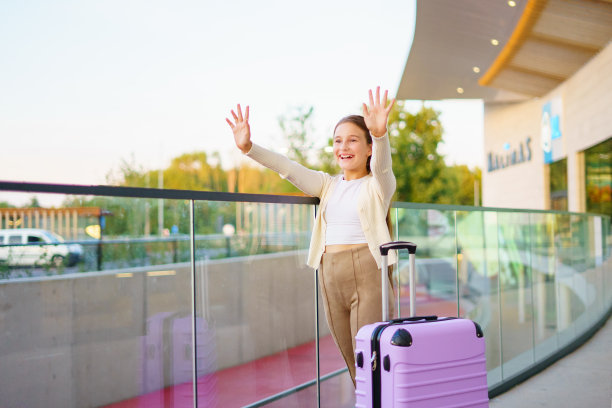 可爱的小女孩提着行李箱在候机楼外等候图片下载
