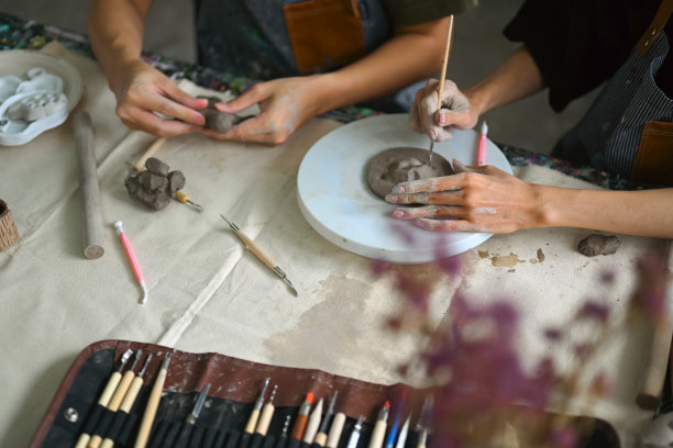 工匠们系着围裙，在车间里用生粘土制作和装饰陶器。图片下载