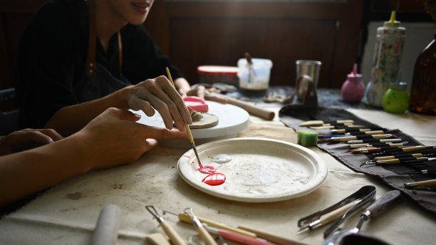 年轻的亚洲男子在陶艺工坊享受创作过程，制作手工陶瓷。图片下载