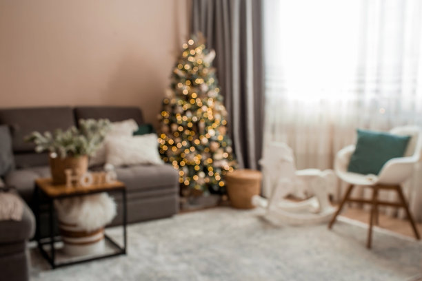 2023年美丽的新年背景。抽象模糊散景光。室内装饰舒适的圣诞房，一棵装饰着花环的圣诞树。房子里喜庆的客厅。图片下载