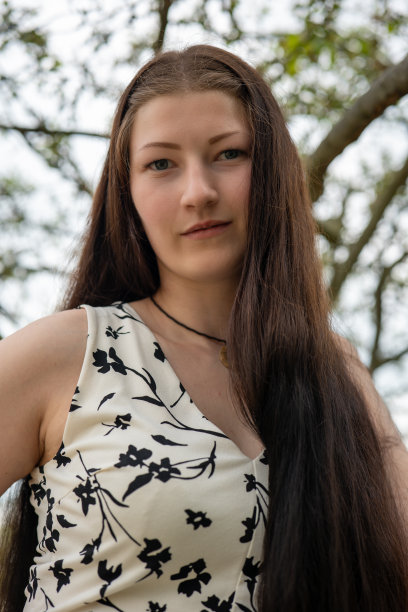 身穿白色夏装、饰有黑色花朵的女子图片下载