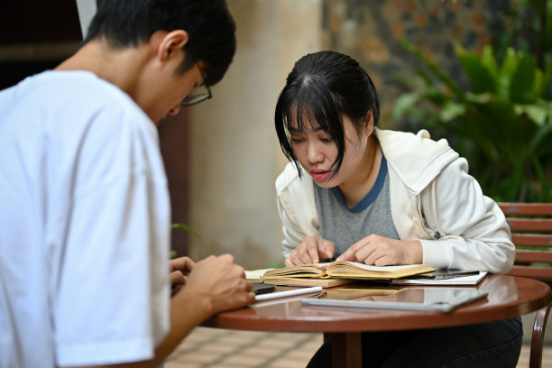一位困惑的亚洲女大学生正在和她的男性朋友一起学习和做作业图片下载