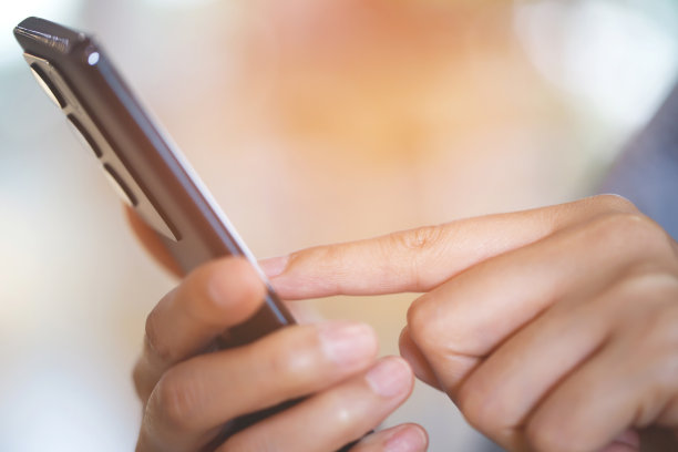 生活方式女人近距离使用手机坐在沙发颜色红色。图片下载