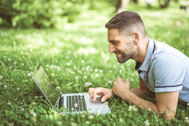快乐开朗的男人带着笔记本电脑在户外享受大自然，自由快乐的理念图片下载
