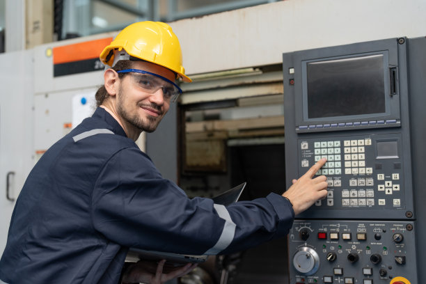 男工程师在工厂控制面板上操作数控机床图片下载