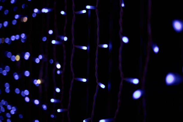 用垂直窗帘和白色和蓝色圆灯装饰的圣诞花环。图片下载