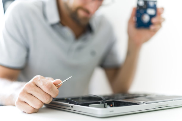 英俊的工程师正在修理笔记本电脑。图片下载