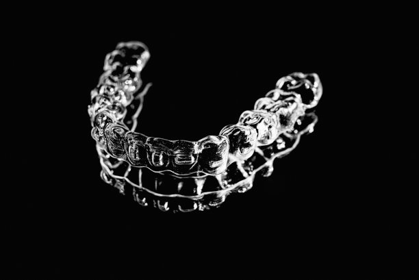看不见的牙齿矫正器牙齿固定器躺在镜子上的黑白照片图片下载