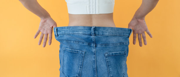 女性显示节食的结果。美丽的形状。女性在参加减肥课程后腰围变小了。因为减肥不能穿牛仔裤。平衡，控制，惯例，锻炼。图片下载