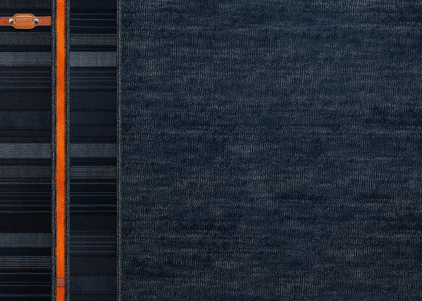 黑色牛仔背景与条纹边界和小皮革标签。深灰色和橘色牛仔牛仔裤的面料质感。文本复制空间图片下载