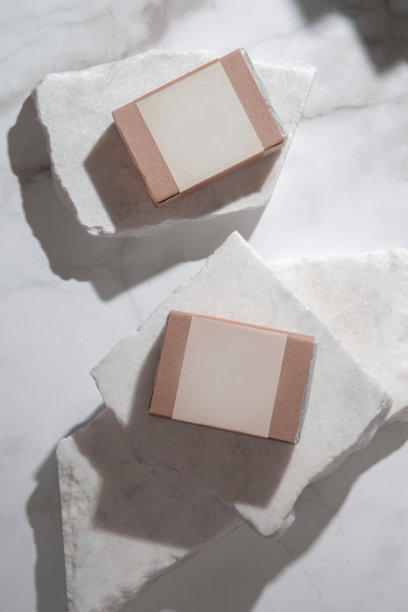 天然香皂，健康的皮肤和头发，在回收纸包装与空白标签，工作室拍摄大理石背景。化妆品的品牌和广告。图片下载