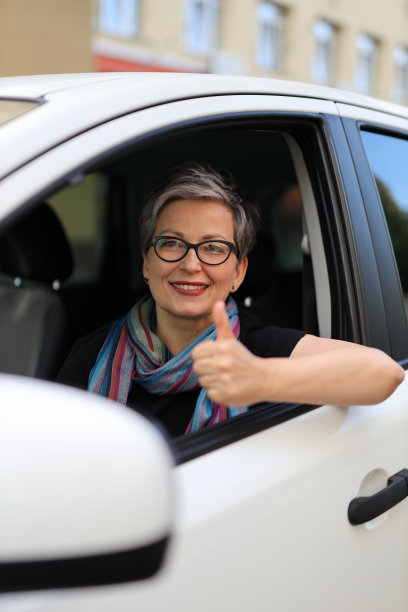 快乐的资深女司机竖起大拇指。图片下载